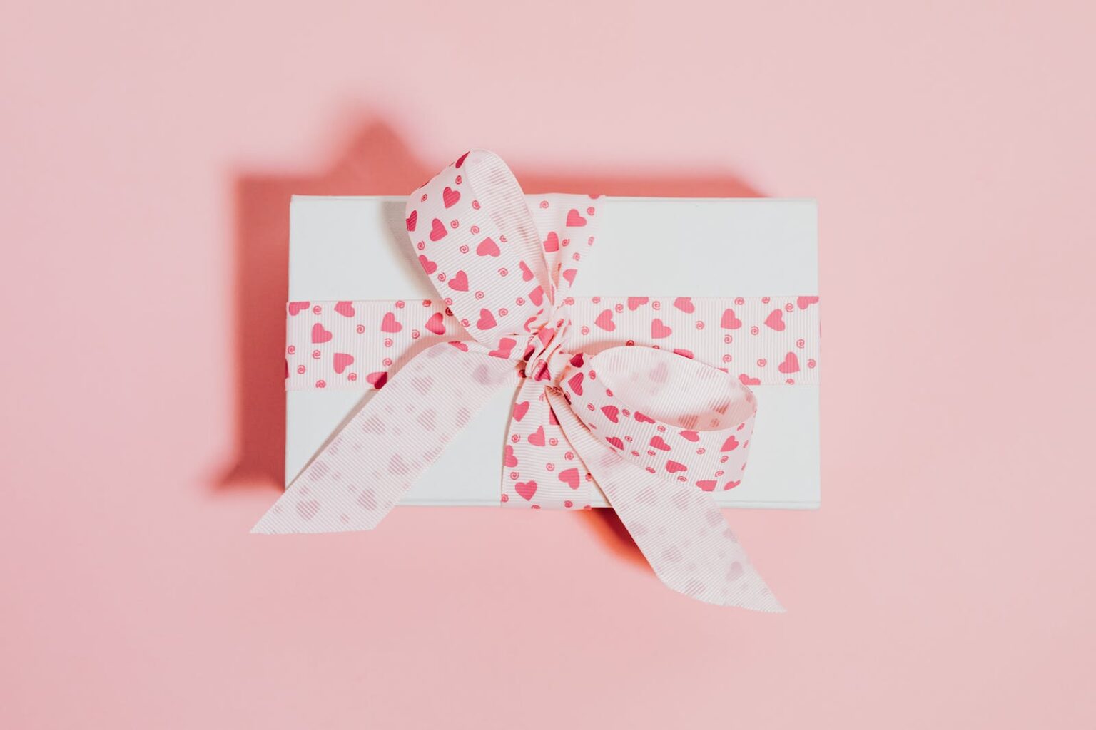 Envelope with Bow on Pink Studio Background