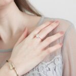 woman in white lace top wearing gold ring