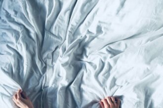 person holding white bedspread